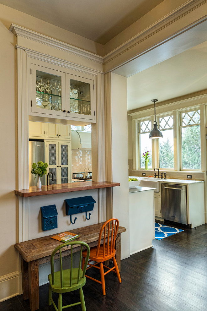 Inspiration for a mid-sized timeless u-shaped dark wood floor eat-in kitchen remodel in Portland with a farmhouse sink, white cabinets, stainless steel appliances, beige backsplash, ceramic backsplash, shaker cabinets, stainless steel countertops and an island
