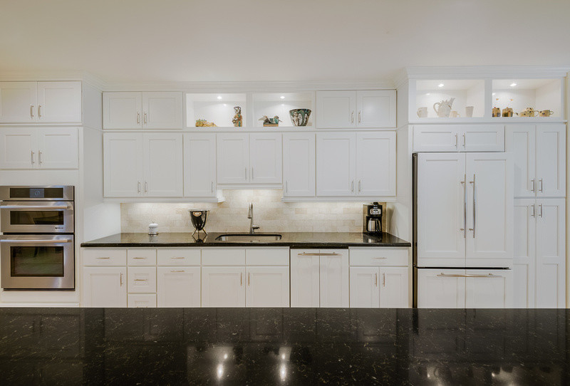 Kitchen - kitchen idea in Miami with an undermount sink, shaker cabinets, white cabinets, quartz countertops, beige backsplash, stone tile backsplash and paneled appliances