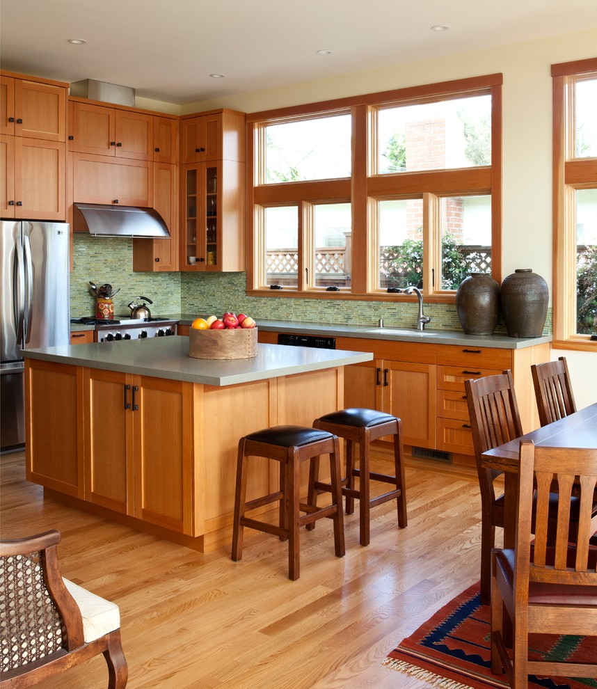 Mid-sized transitional l-shaped medium tone wood floor eat-in kitchen photo in San Francisco with an undermount sink, shaker cabinets, medium tone wood cabinets, quartz countertops, green backsplash, glass tile backsplash, stainless steel appliances and an island