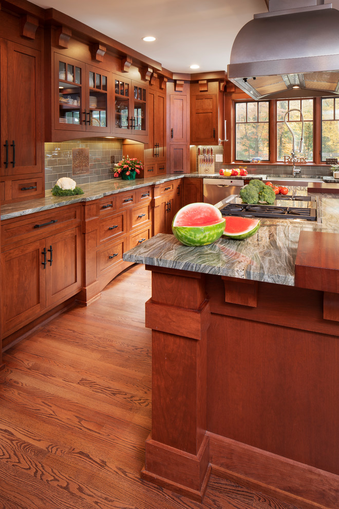 Large classic l-shaped kitchen/diner in New York with a belfast sink, shaker cabinets, medium wood cabinets, wood worktops, green splashback, metro tiled splashback, stainless steel appliances, medium hardwood flooring, an island, brown floors and brown worktops.