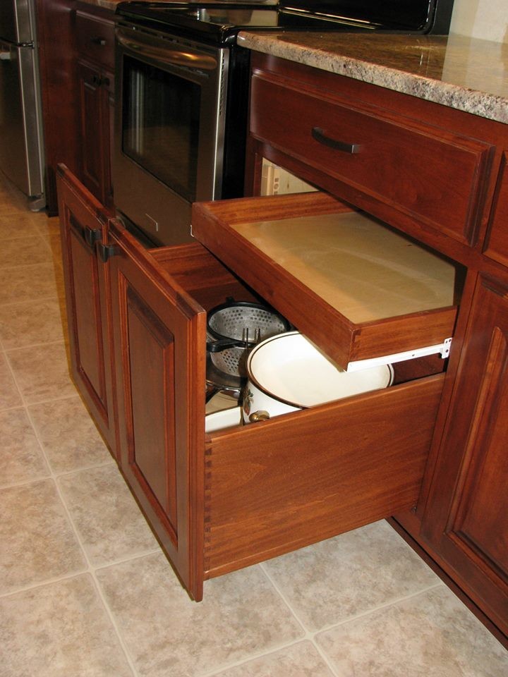 Example of a mid-sized classic linoleum floor enclosed kitchen design in Other with an undermount sink, raised-panel cabinets, red cabinets, granite countertops, brown backsplash, glass tile backsplash, stainless steel appliances and an island