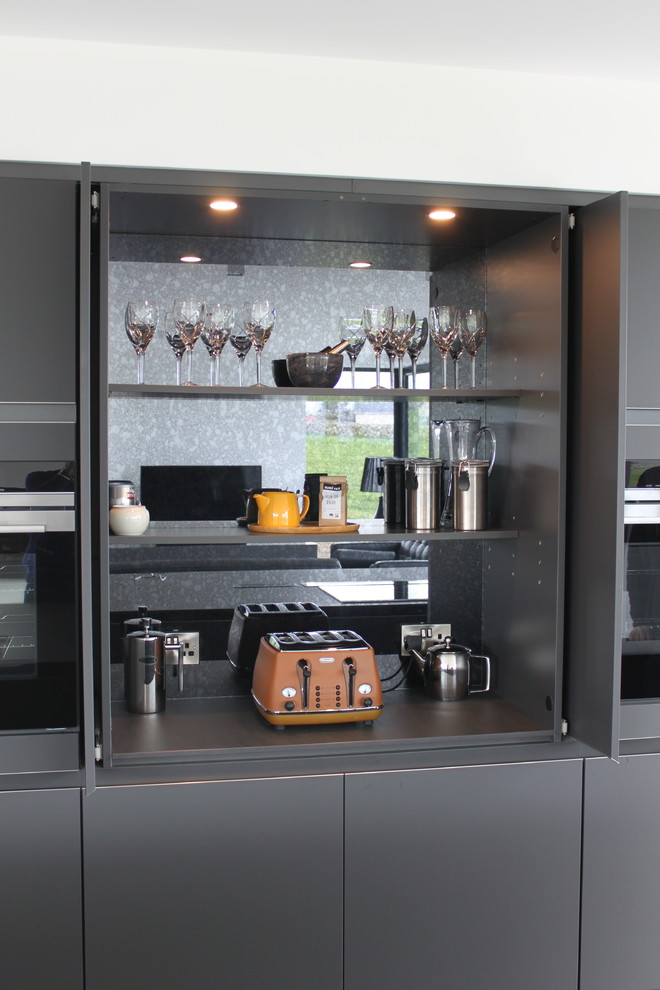 Photo of a large contemporary galley open plan kitchen in Other with an integrated sink, flat-panel cabinets, grey cabinets, composite countertops, black appliances, porcelain flooring and an island.