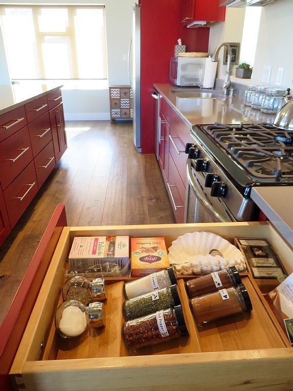 Inspiration for a small industrial single-wall medium tone wood floor open concept kitchen remodel in Denver with an undermount sink, flat-panel cabinets, red cabinets, quartz countertops, gray backsplash, stainless steel appliances and an island
