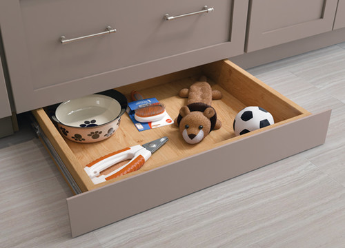 floor height drawer in kitchen with dog toys and other dog supplies.