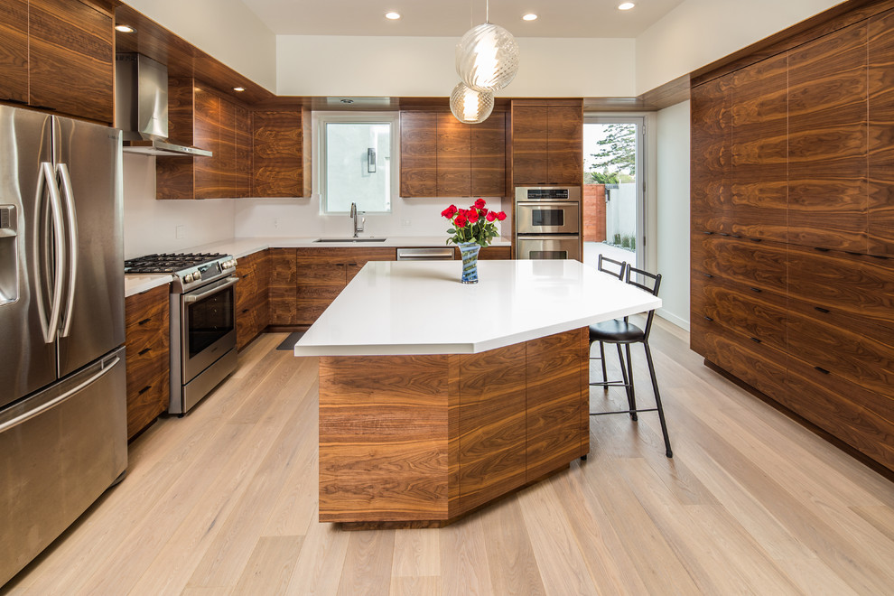 Inspiration for a contemporary u-shaped light wood floor kitchen remodel in San Diego with an undermount sink, flat-panel cabinets, medium tone wood cabinets, quartzite countertops, white backsplash, stainless steel appliances and an island