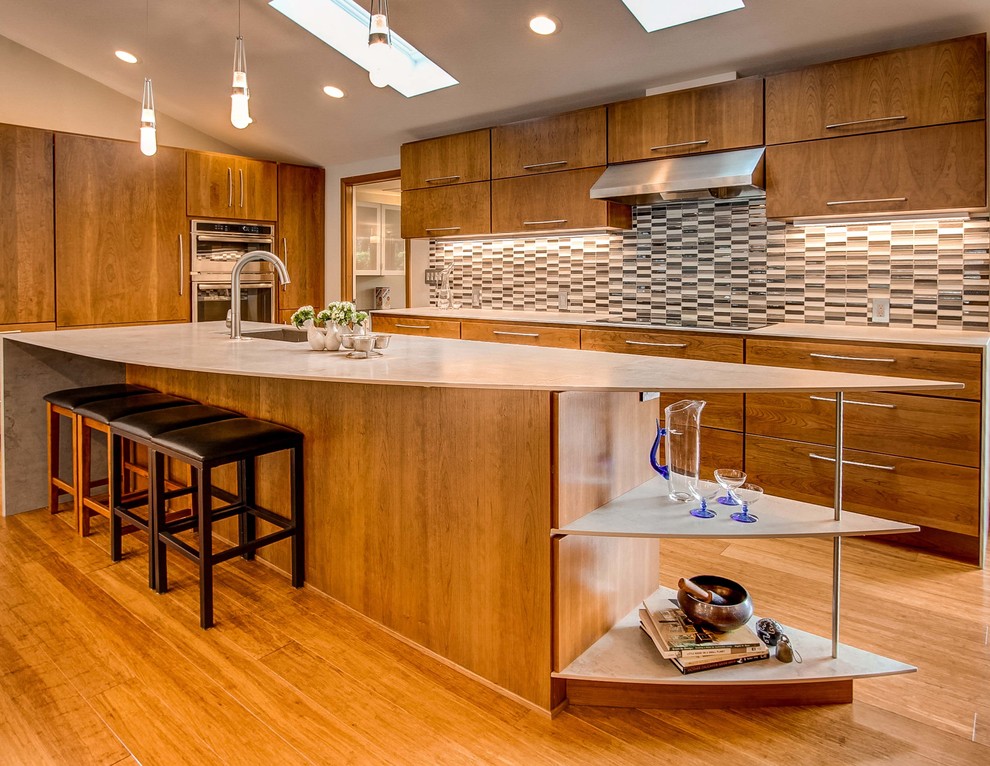 Example of a mid-sized minimalist l-shaped medium tone wood floor eat-in kitchen design in Denver with an undermount sink, flat-panel cabinets, medium tone wood cabinets, multicolored backsplash, glass tile backsplash, stainless steel appliances and an island