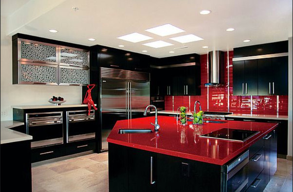 На фото: большая п-образная кухня в стиле модернизм с врезной мойкой, плоскими фасадами, черными фасадами, красным фартуком, фартуком из керамической плитки, техникой из нержавеющей стали, полом из известняка и островом