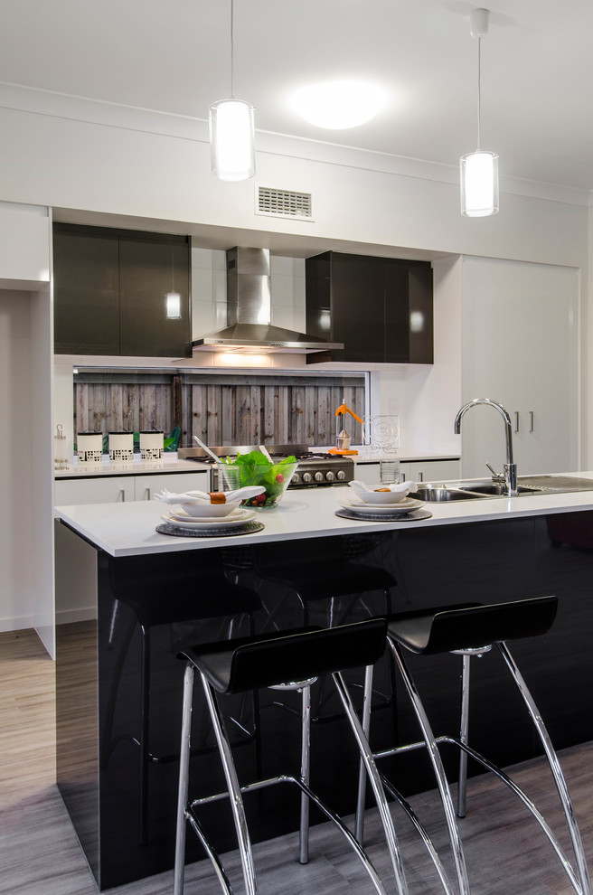 Mid-sized trendy galley vinyl floor eat-in kitchen photo in Brisbane with a double-bowl sink, flat-panel cabinets, black cabinets, quartzite countertops, stainless steel appliances and an island
