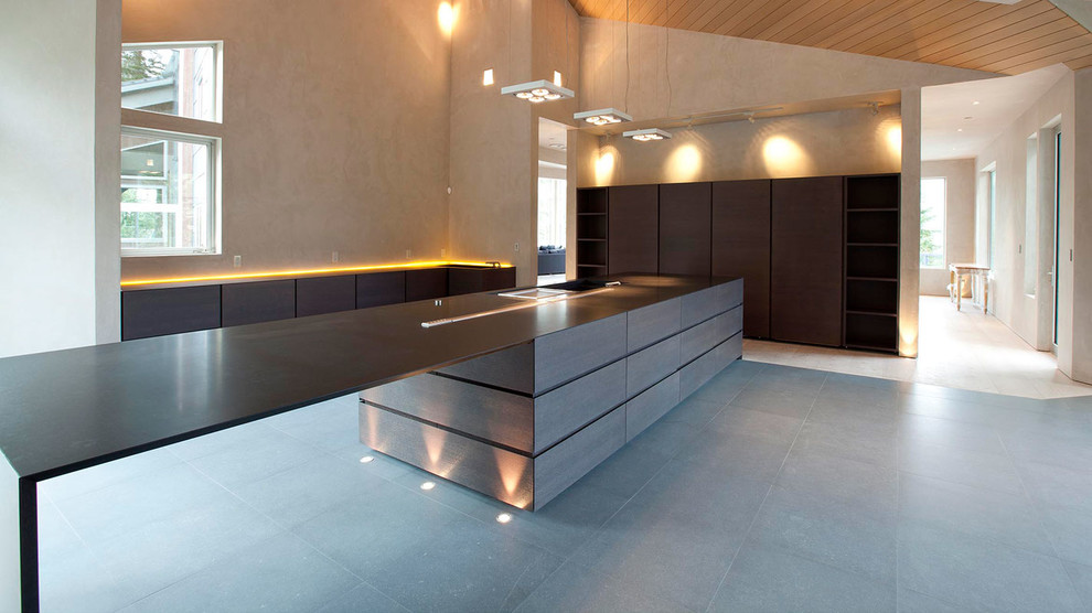 Esempio di una cucina minimal con lavello sottopiano, ante lisce, ante beige, top in cemento, elettrodomestici da incasso e pavimento in pietra calcarea