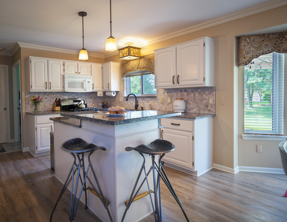 Idéer för att renovera ett mellanstort vintage kök, med en undermonterad diskho, luckor med upphöjd panel, vita skåp, granitbänkskiva, grått stänkskydd, stänkskydd i porslinskakel, vita vitvaror, en köksö och brunt golv
