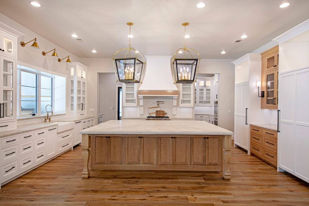 Example of a large transitional u-shaped medium tone wood floor kitchen pantry design in Dallas with shaker cabinets, white cabinets, quartz countertops, white backsplash, ceramic backsplash, stainless steel appliances, an island and white countertops