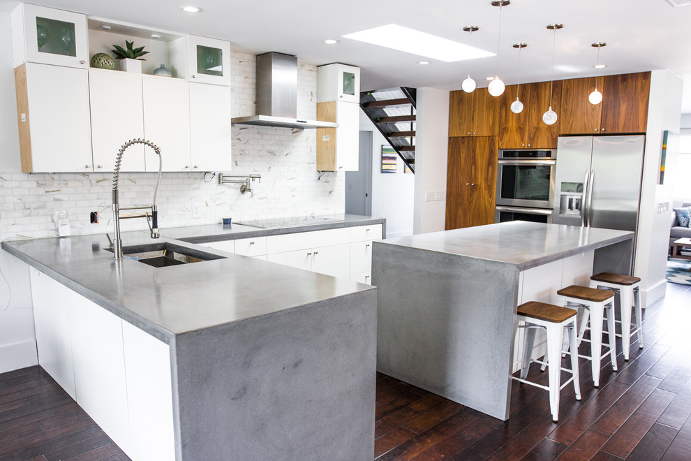 Cette photo montre une cuisine moderne en L de taille moyenne avec un plan de travail en béton, parquet foncé et îlot.