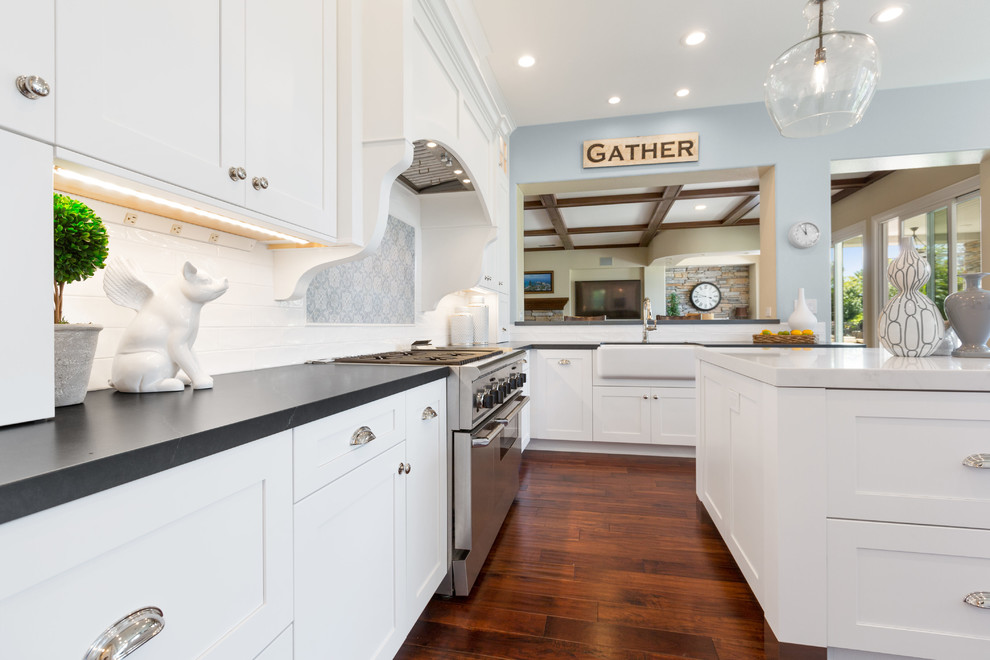 Kitchen pantry - large transitional u-shaped dark wood floor and brown floor kitchen pantry idea in Tampa with a farmhouse sink, shaker cabinets, white cabinets, soapstone countertops, white backsplash, subway tile backsplash, stainless steel appliances, an island and gray countertops