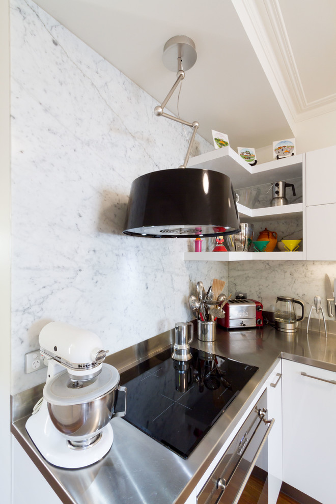 Small contemporary l-shaped kitchen pantry in Melbourne with an integrated sink, flat-panel cabinets, white cabinets, stainless steel worktops, white splashback, marble splashback, stainless steel appliances, medium hardwood flooring and brown floors.