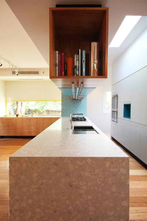 Exempel på ett mellanstort modernt linjärt kök med öppen planlösning, med släta luckor, vita skåp, granitbänkskiva, vitt stänkskydd, glaspanel som stänkskydd, rostfria vitvaror och en köksö