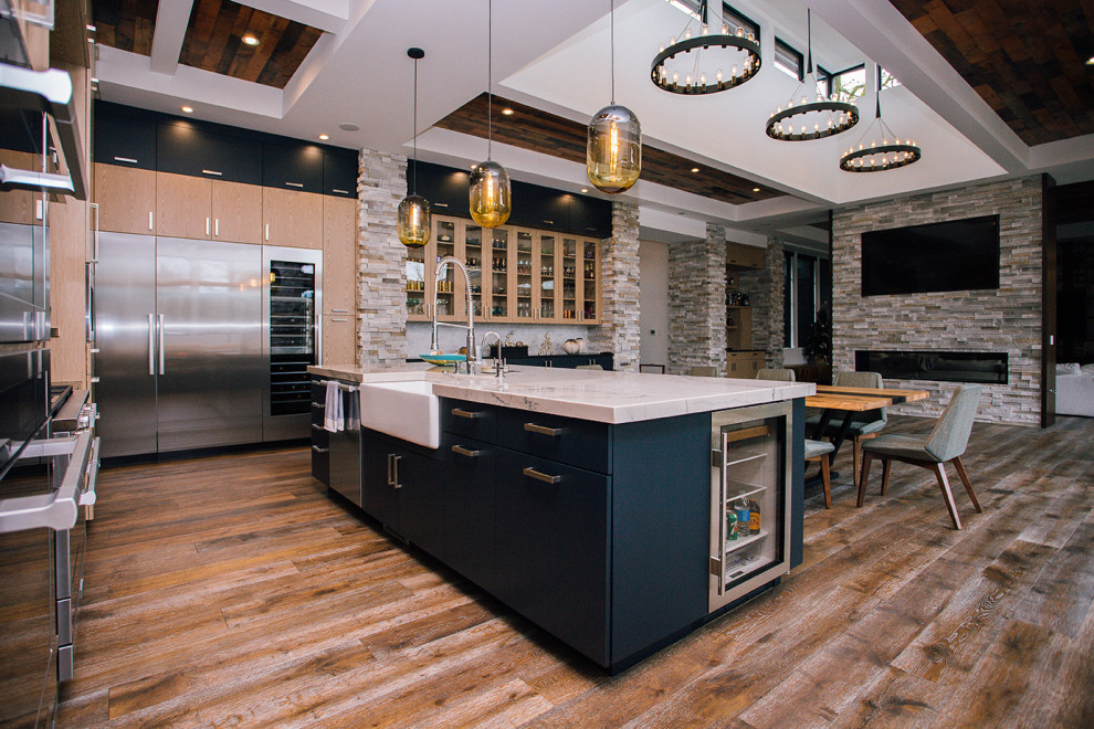 Example of a huge trendy l-shaped medium tone wood floor and brown floor eat-in kitchen design in Portland with flat-panel cabinets, light wood cabinets, multicolored backsplash, an island, multicolored countertops, an undermount sink, quartz countertops, subway tile backsplash and black appliances