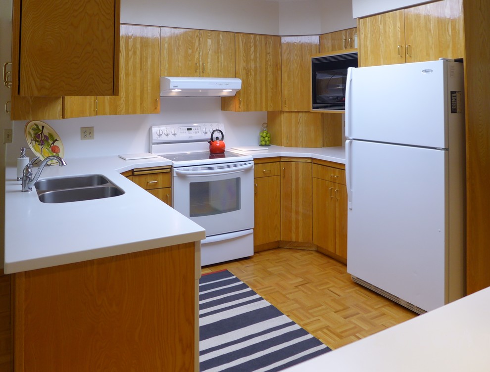 Esempio di una cucina minimal con lavello sottopiano, ante in legno scuro, top in superficie solida e elettrodomestici bianchi