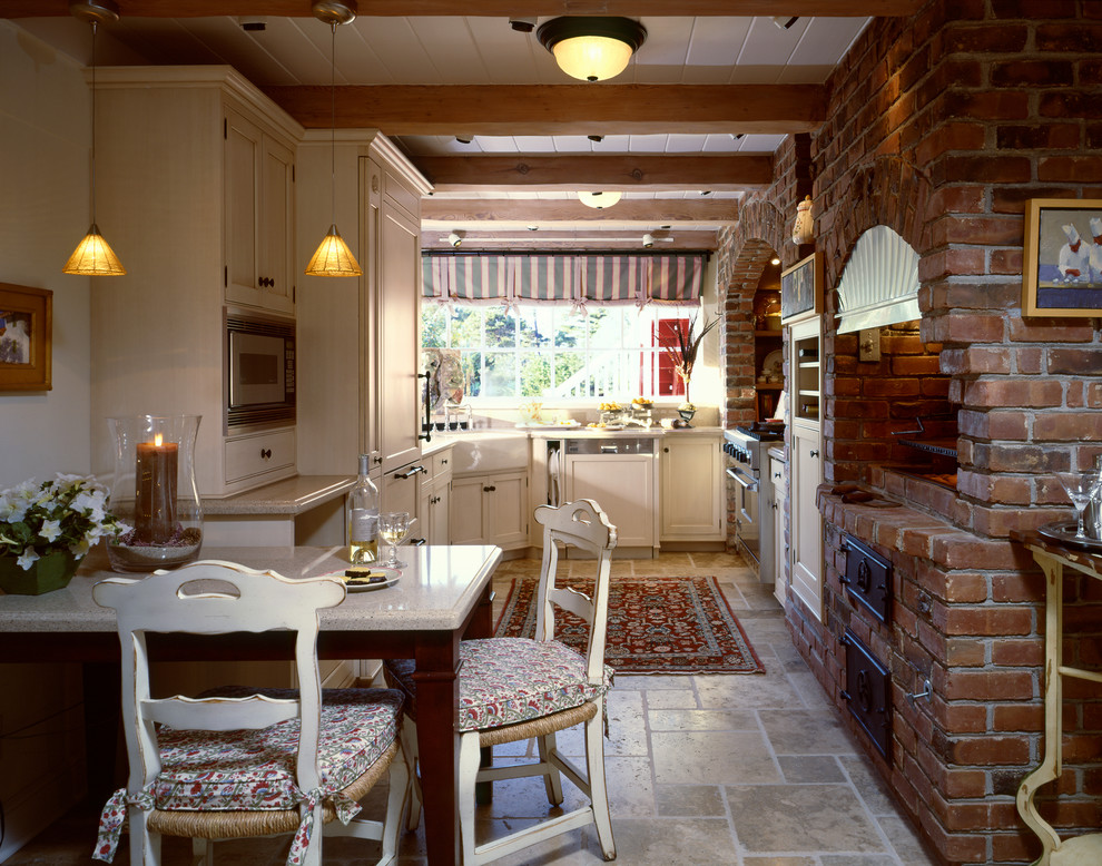 Aménagement d'une cuisine classique en U fermée avec des portes de placard beiges et un sol en travertin.