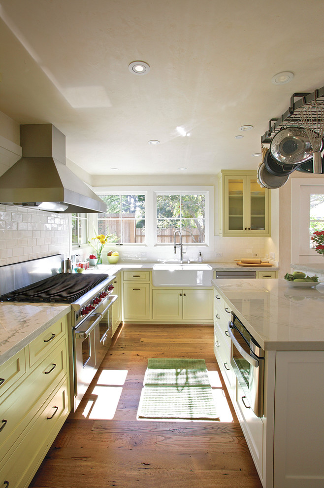 Design ideas for a rural kitchen in Other with a belfast sink, shaker cabinets, yellow cabinets, white splashback, metro tiled splashback and stainless steel appliances.