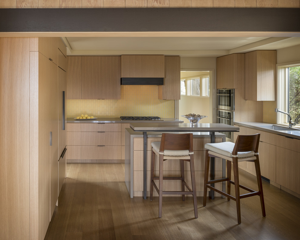 Enclosed kitchen - mid-sized modern u-shaped light wood floor and beige floor enclosed kitchen idea in Other with an undermount sink, flat-panel cabinets, light wood cabinets, yellow backsplash, porcelain backsplash, paneled appliances, an island and gray countertops