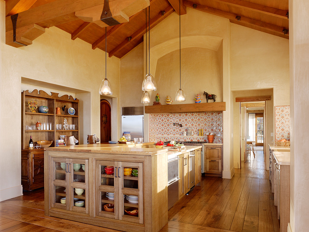 サンフランシスコにある地中海スタイルのおしゃれなキッチン (淡色木目調キャビネット、マルチカラーのキッチンパネル、シルバーの調理設備) の写真