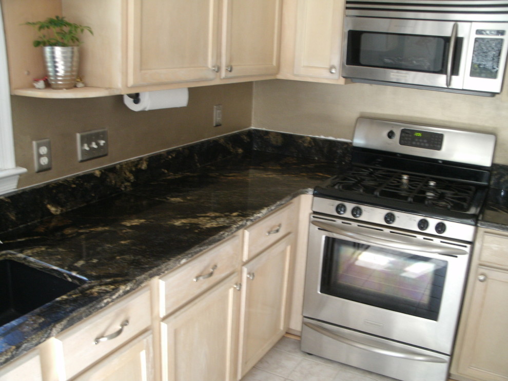 Immagine di una cucina contemporanea con lavello a vasca singola, top in granito, paraspruzzi nero, paraspruzzi in lastra di pietra e elettrodomestici in acciaio inossidabile