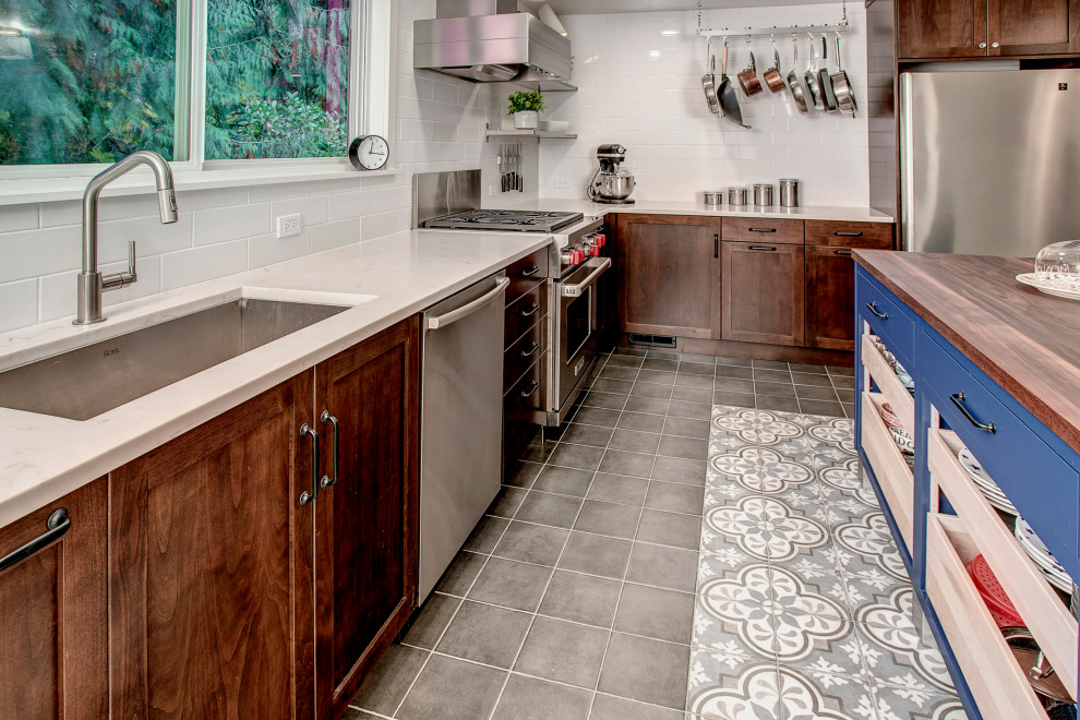 Eat-in kitchen - mid-sized transitional porcelain tile and gray floor eat-in kitchen idea in Seattle with a single-bowl sink, shaker cabinets, medium tone wood cabinets, wood countertops, white backsplash, porcelain backsplash, stainless steel appliances, an island and brown countertops