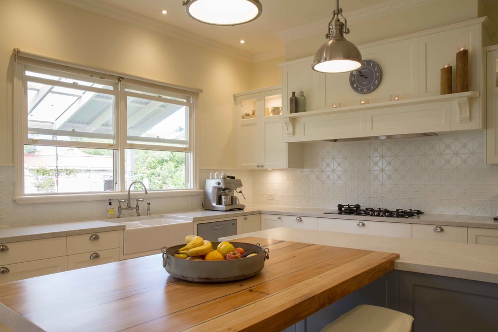 Example of a large classic u-shaped light wood floor open concept kitchen design in Melbourne with shaker cabinets and an island