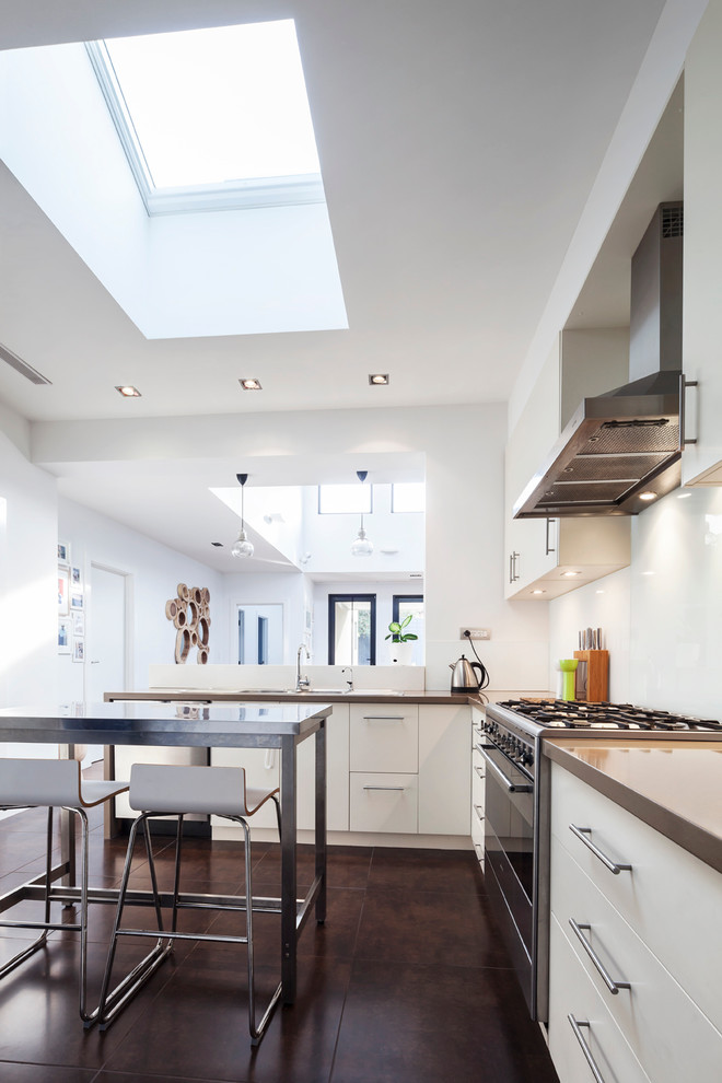 Moderne Küche mit flächenbündigen Schrankfronten, weißen Schränken, Küchenrückwand in Weiß, Küchengeräten aus Edelstahl, Kücheninsel und braunem Boden in Melbourne