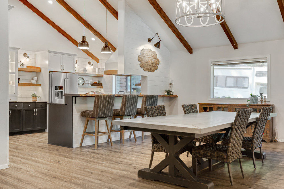 Immagine di una sala da pranzo aperta verso la cucina country di medie dimensioni con pavimento marrone