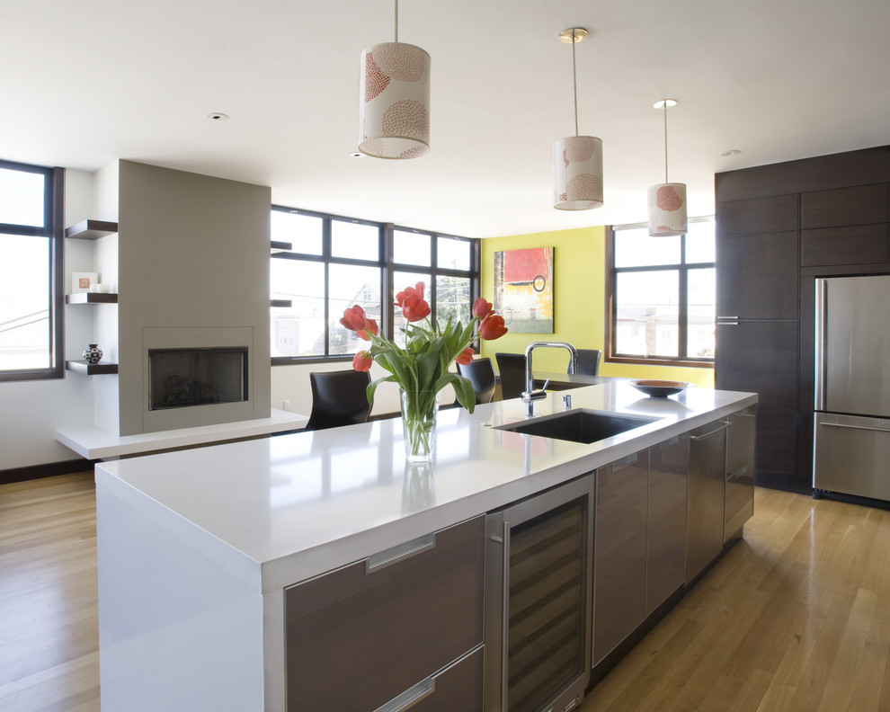 Foto di una cucina ad ambiente unico design con elettrodomestici in acciaio inossidabile, lavello a vasca singola, ante lisce e ante in legno bruno