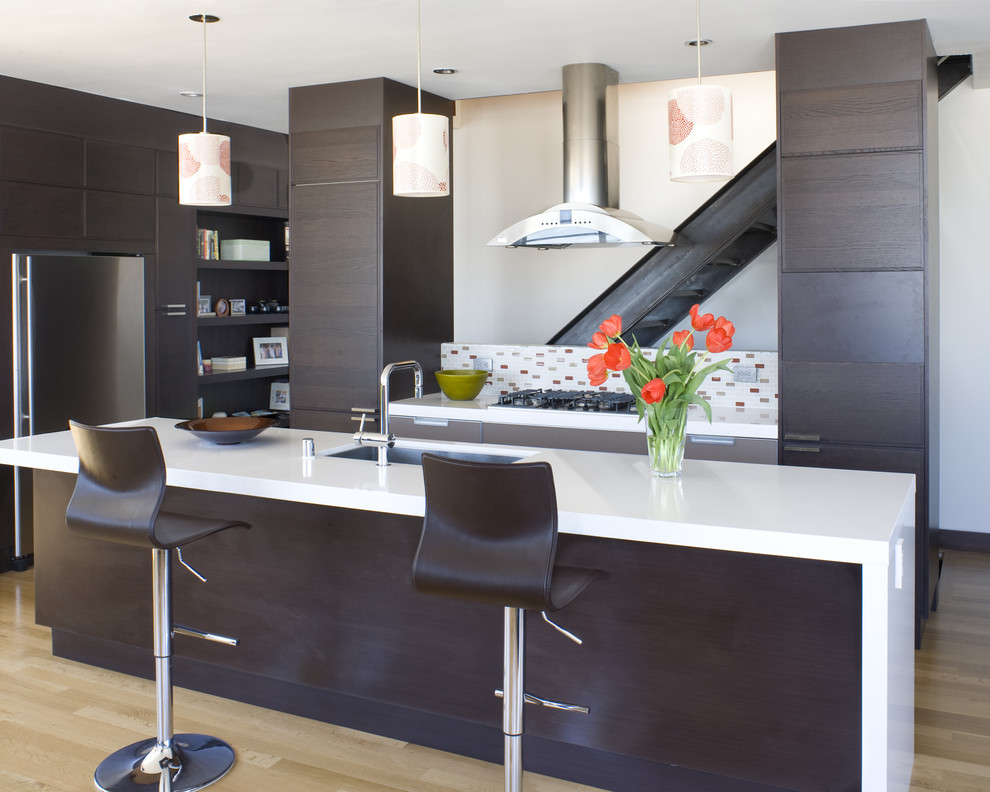 Contemporary kitchen in San Francisco with stainless steel appliances, a submerged sink, flat-panel cabinets, dark wood cabinets, multi-coloured splashback and engineered stone countertops.