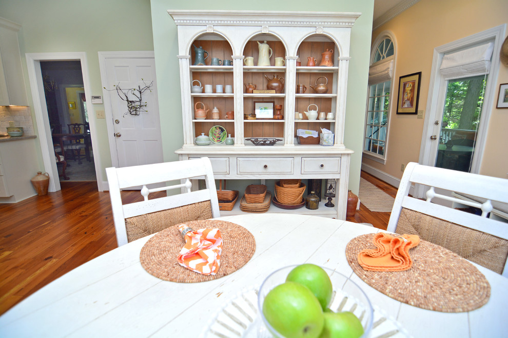 Bild på ett tropiskt kök, med en undermonterad diskho, luckor med infälld panel, vita skåp, granitbänkskiva, beige stänkskydd, stänkskydd i stenkakel, rostfria vitvaror, mellanmörkt trägolv och en köksö