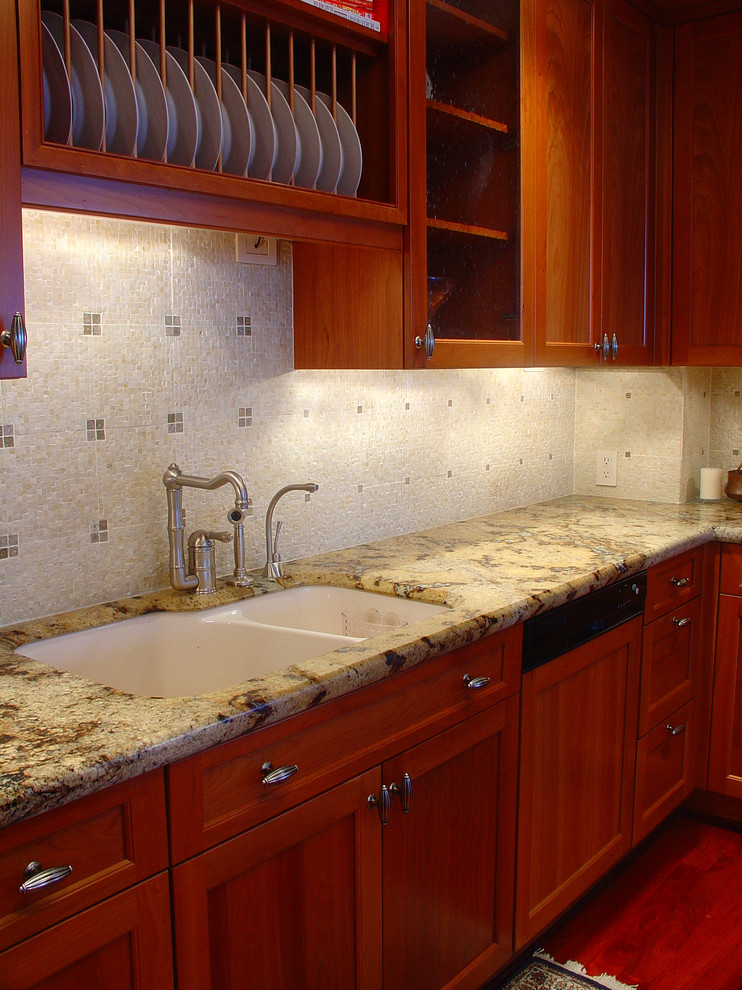 Klassisk inredning av ett litet kök, med en undermonterad diskho, skåp i shakerstil, skåp i mellenmörkt trä, granitbänkskiva, beige stänkskydd, stänkskydd i stenkakel, rostfria vitvaror, mellanmörkt trägolv och en halv köksö