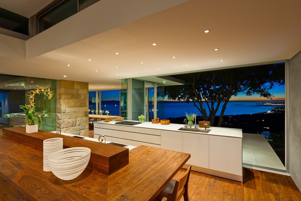 На фото: кухня в стиле модернизм с деревянной столешницей, плоскими фасадами и белыми фасадами с