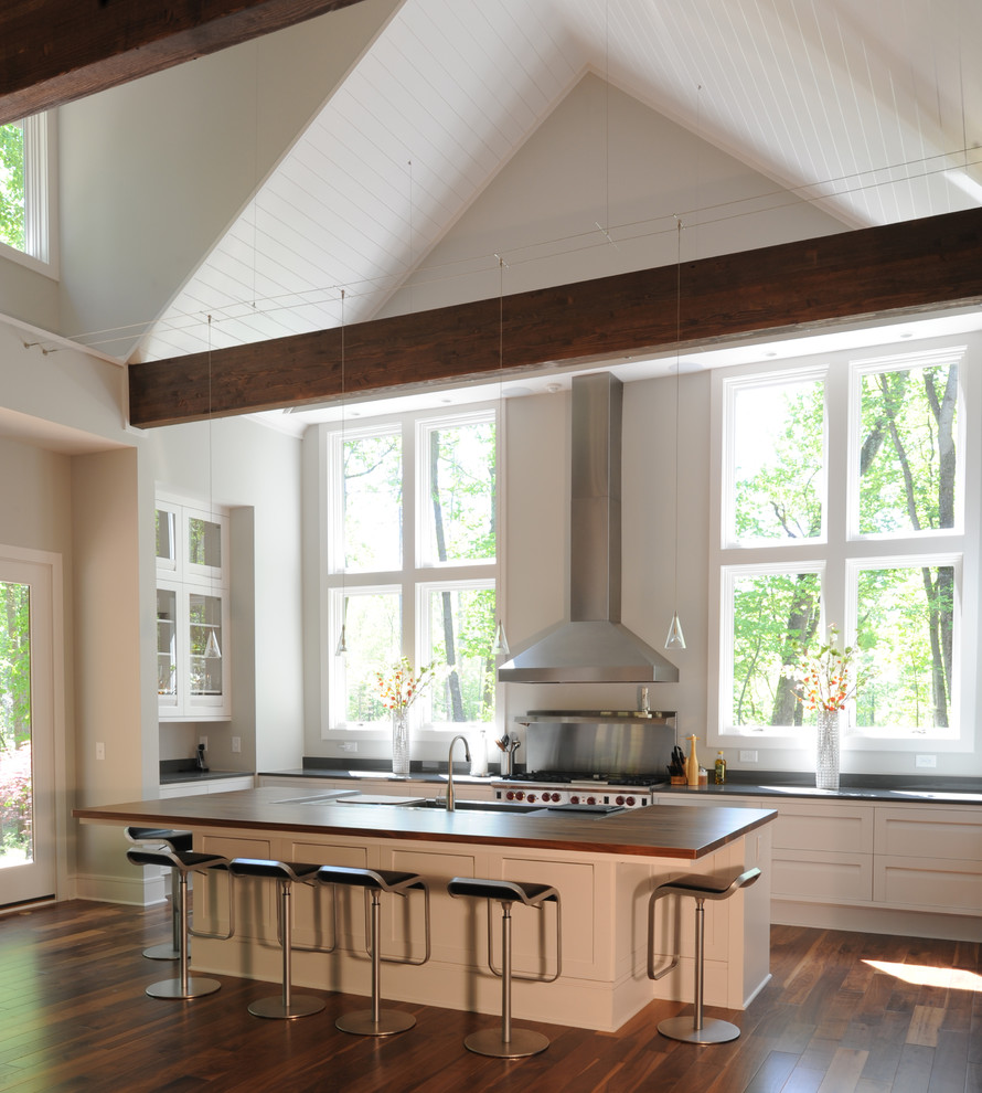 Пример оригинального дизайна: кухня в стиле модернизм с техникой из нержавеющей стали, деревянной столешницей и белыми фасадами