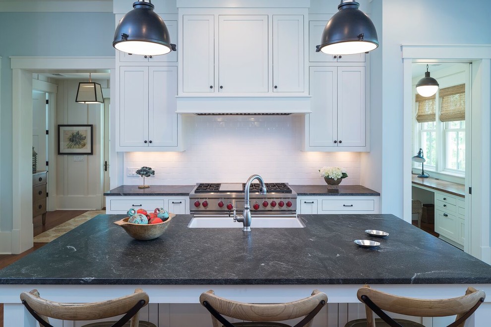 Example of a transitional medium tone wood floor eat-in kitchen design in Atlanta with a farmhouse sink, beaded inset cabinets, white cabinets, white backsplash, subway tile backsplash and an island