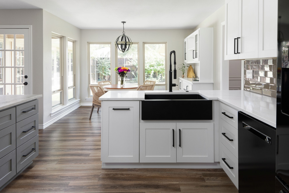 Idéer för att renovera ett stort funkis vit vitt l-kök, med en rustik diskho, skåp i shakerstil, vita skåp, bänkskiva i kvartsit, grått stänkskydd, stänkskydd i glaskakel, svarta vitvaror, mellanmörkt trägolv, en köksö och brunt golv