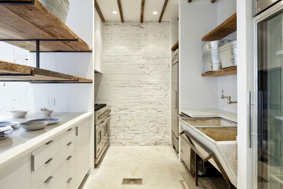 Eat-in kitchen - small country galley concrete floor eat-in kitchen idea in DC Metro with a farmhouse sink, flat-panel cabinets, white cabinets, soapstone countertops, stainless steel appliances and no island