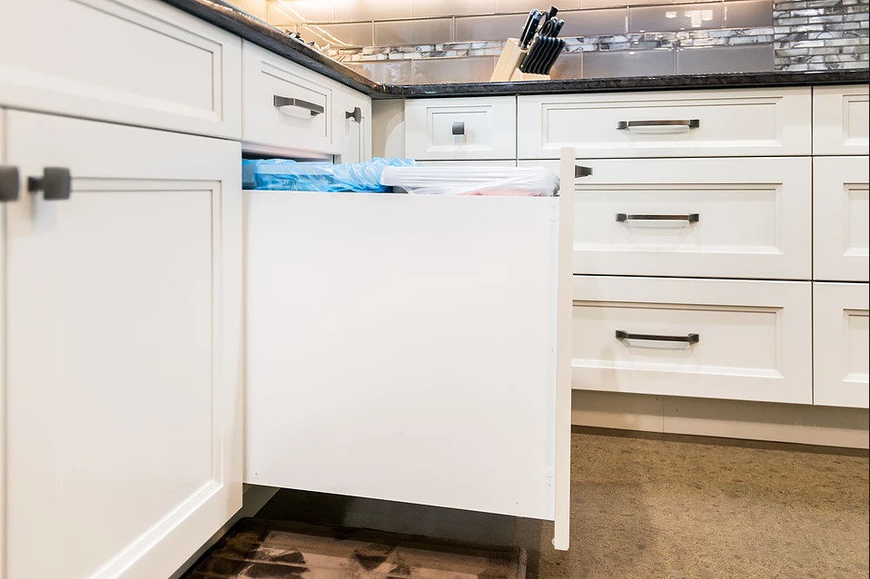 Bild på ett stort funkis u-kök, med en dubbel diskho, luckor med infälld panel, vita skåp, granitbänkskiva, brunt stänkskydd, stänkskydd i tunnelbanekakel, rostfria vitvaror, en köksö och brunt golv