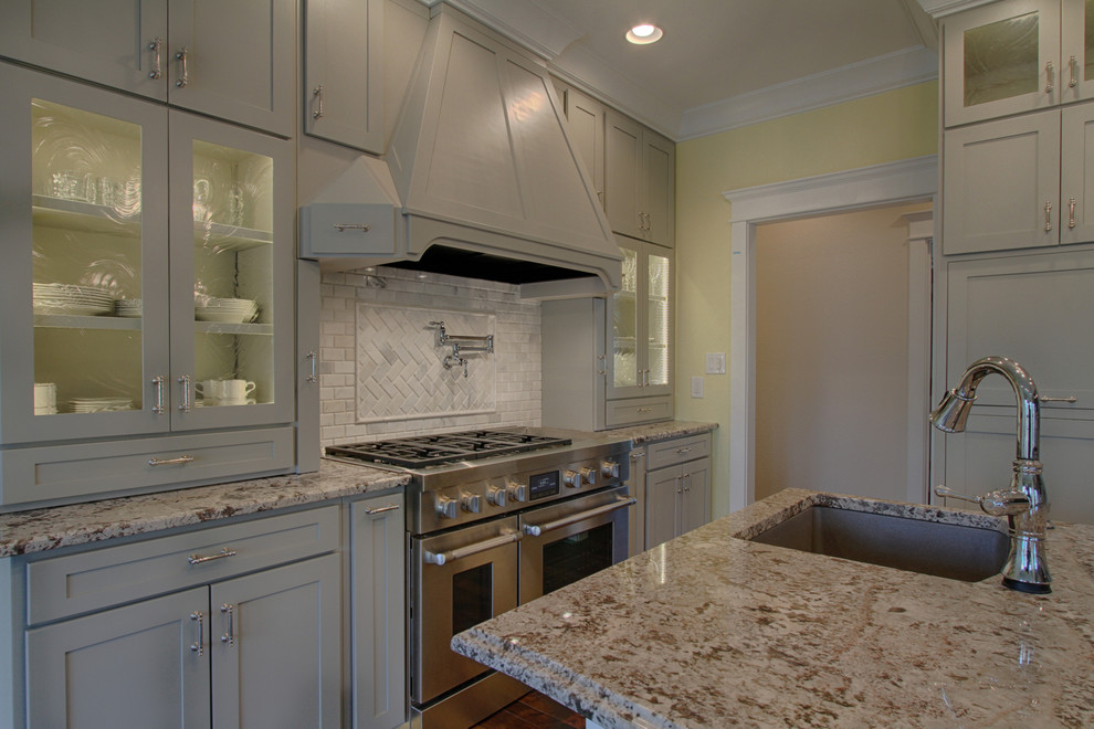 Foto di una grande cucina minimalista con lavello sottopiano e top in granito