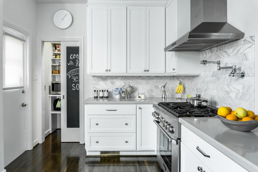 Klassische Küche in grau-weiß ohne Insel in L-Form mit Schrankfronten mit vertiefter Füllung, weißen Schränken, Küchenrückwand in Grau, Küchengeräten aus Edelstahl, dunklem Holzboden und Rückwand aus Marmor in Los Angeles