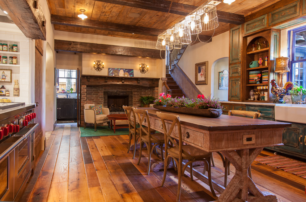 Example of a mountain style galley eat-in kitchen design in Dallas with a farmhouse sink, raised-panel cabinets, stainless steel appliances, distressed cabinets, white backsplash, subway tile backsplash and wood countertops