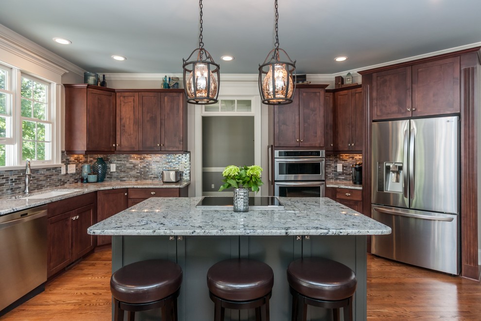 Large contemporary kitchen/diner in Raleigh with shaker cabinets, medium wood cabinets, granite worktops, blue splashback, glass sheet splashback, stainless steel appliances, medium hardwood flooring, an island and a built-in sink.