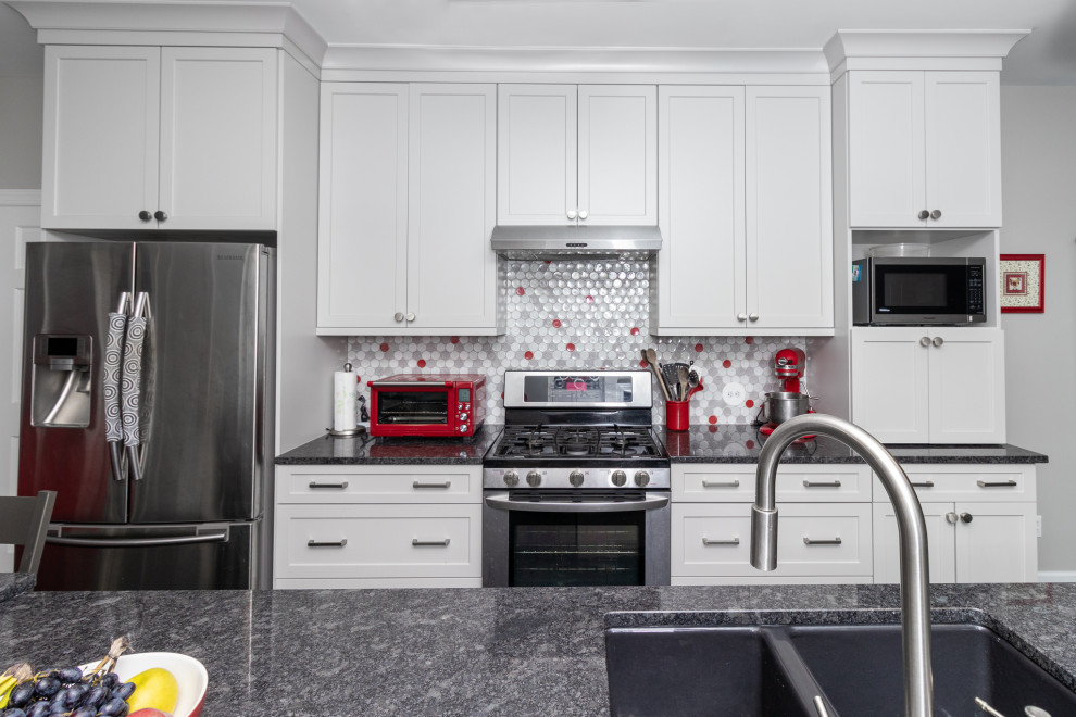 Idéer för att renovera ett mellanstort eklektiskt grå linjärt grått kök, med luckor med infälld panel, vita skåp, bänkskiva i kvarts, flerfärgad stänkskydd och rostfria vitvaror