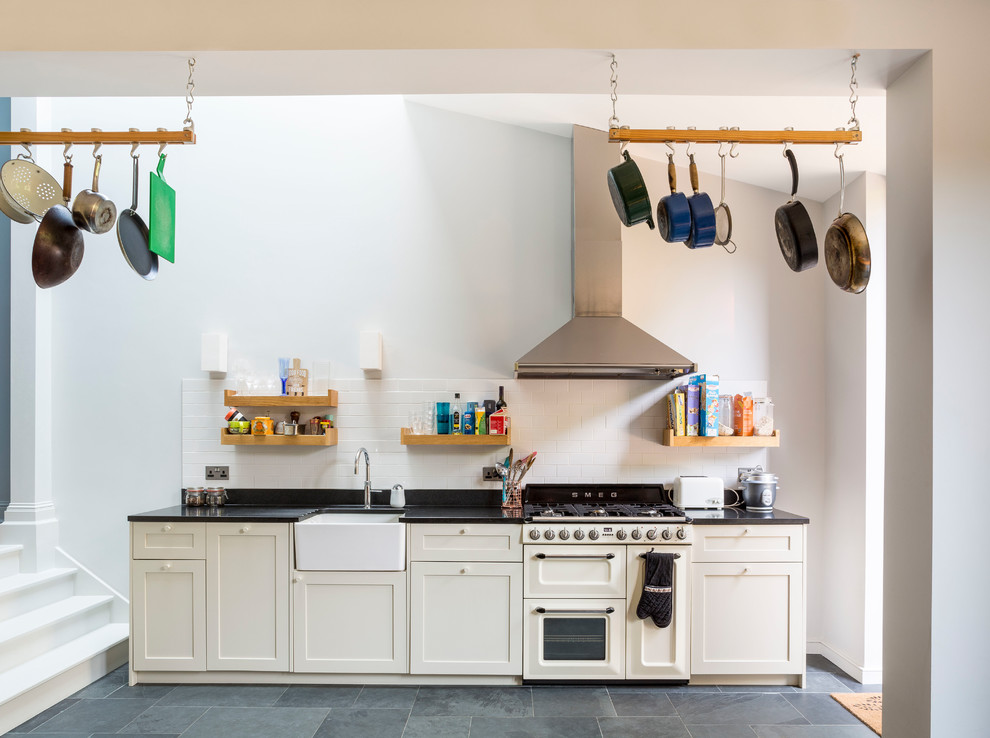 Exempel på ett mellanstort modernt linjärt kök och matrum, med skåp i shakerstil, grå skåp, granitbänkskiva, stänkskydd i tunnelbanekakel, integrerade vitvaror, skiffergolv och svart golv