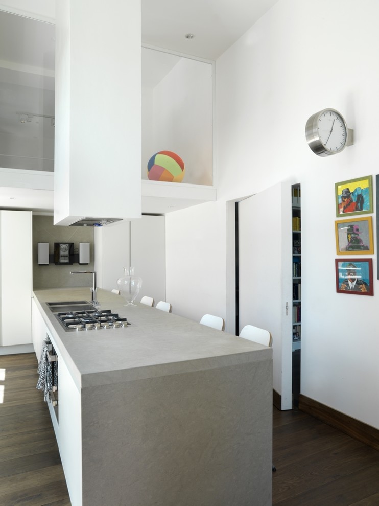 Ispirazione per un cucina con isola centrale minimal con lavello da incasso, ante lisce e pavimento in legno massello medio