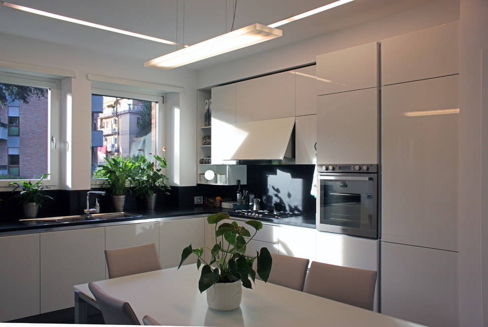 Idéer för ett stort modernt kök, med en dubbel diskho, släta luckor, vita skåp, marmorbänkskiva, svart stänkskydd, stänkskydd i sten, rostfria vitvaror, skiffergolv och en köksö