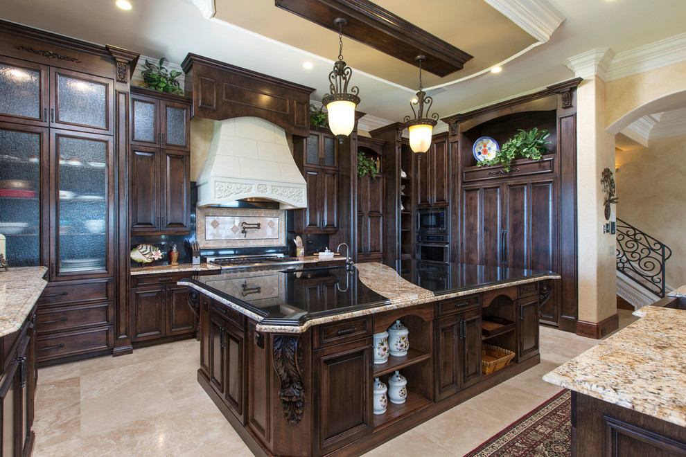 Inspiration for a huge mediterranean u-shaped travertine floor open concept kitchen remodel in Orlando with an undermount sink, beaded inset cabinets, dark wood cabinets, granite countertops, brown backsplash, glass tile backsplash, stainless steel appliances and two islands