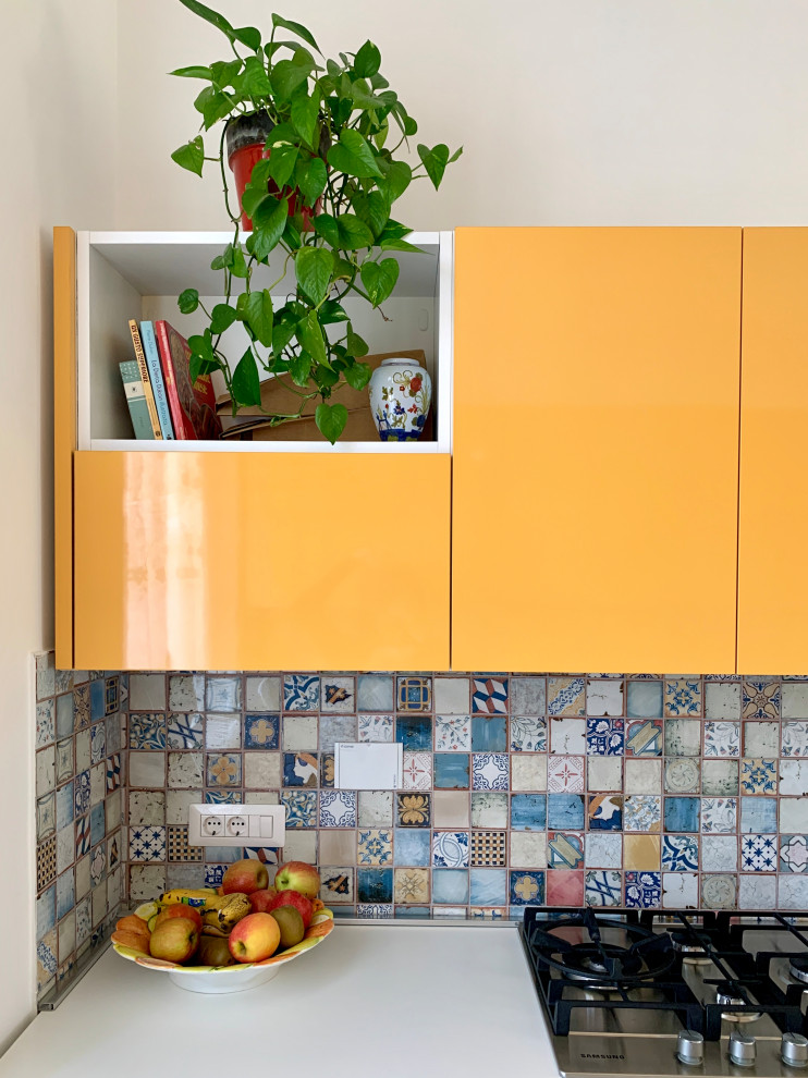 Cette image montre une petite arrière-cuisine parallèle avec un évier 2 bacs, des portes de placard jaunes, une crédence en carreau de ciment, un sol en bois brun et un plan de travail blanc.